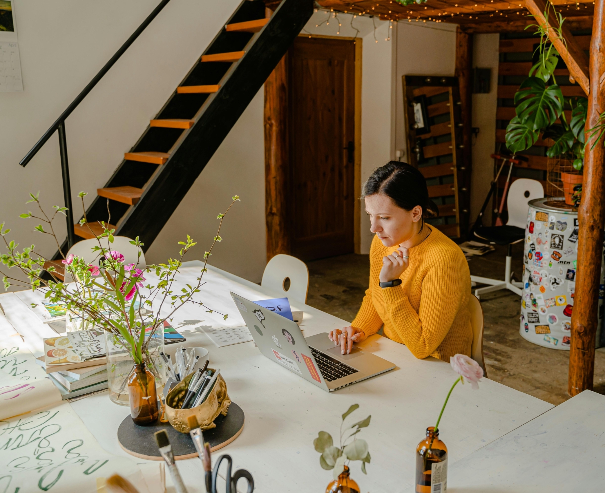 Web-Infoabende an der PHB. Eine junge Frau sitzt an einem Schreibtisch mit ihrem Laptop.