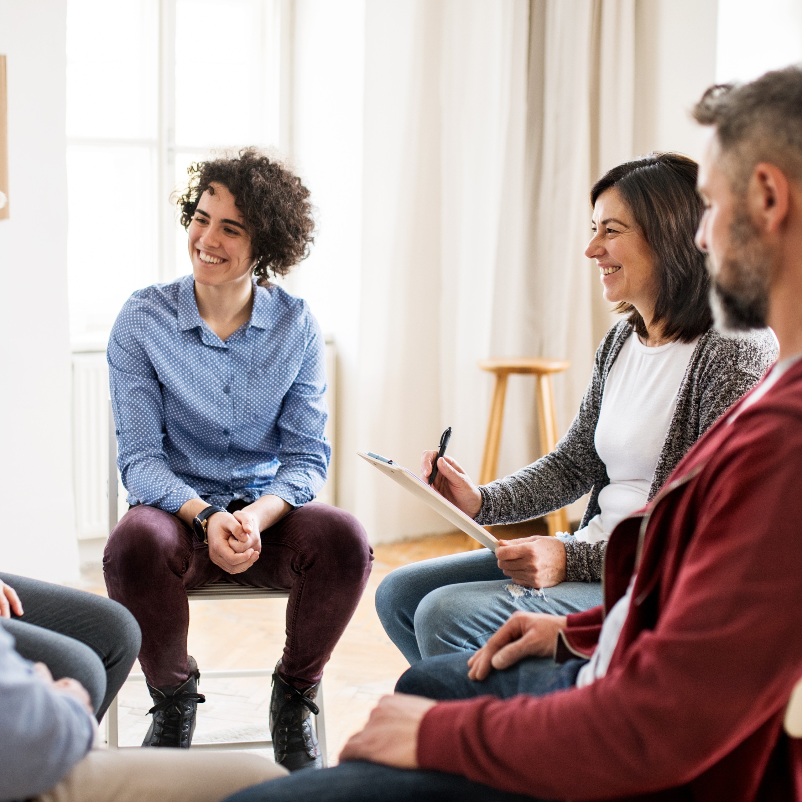 Gruppentherapie in einem hellen Raum.