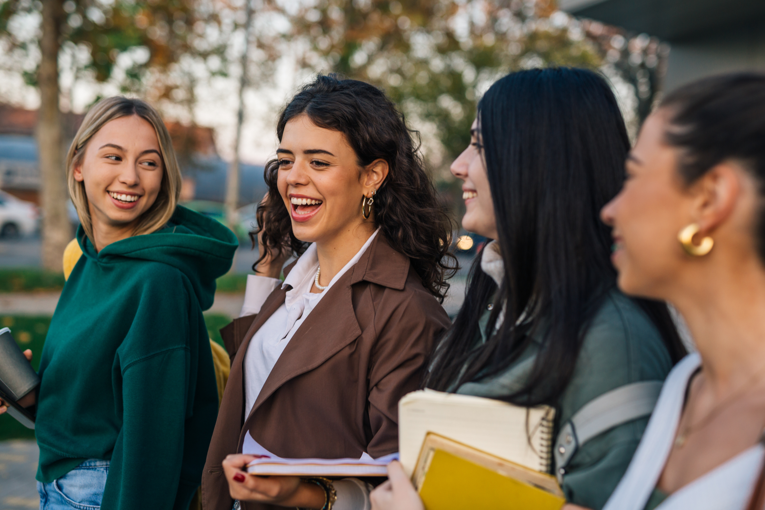Eine Gruppe von jungen Menschen läuft lachend nebeneinander.